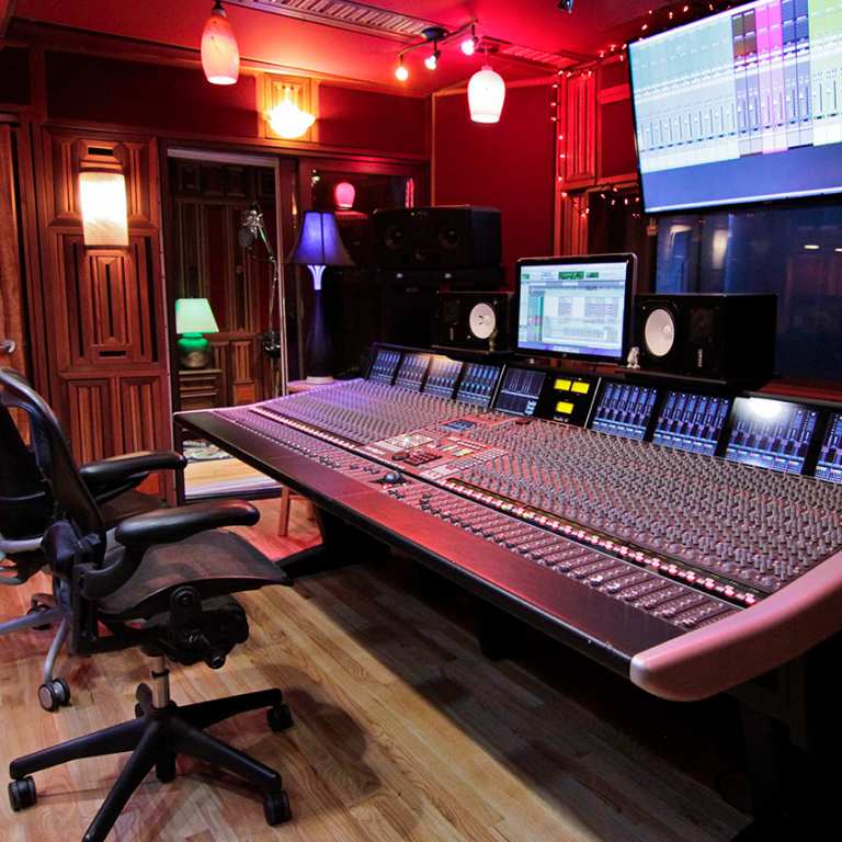 Professional recording studio soundboard with vibrant lighting